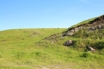 Obraz premium A grassy hill with a rock wall