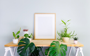 Stylish room interior with mockup photo frame on the wooden shelf with various house plants