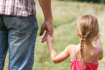 A Hands of happy child and parent on nature in the park family concept