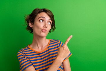 Photo portrait of attractive young woman look unsure point empty space dressed stylish striped...