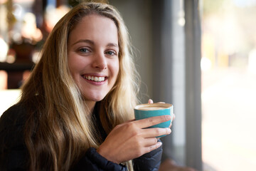 Portrait, drink or girl with coffee in cafe to relax, chill and enjoy warm beverage in Germany....