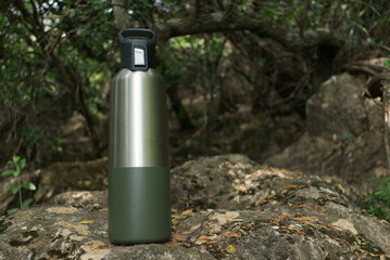 Reusable stainless steel water bottle in the wilderness with space for copy