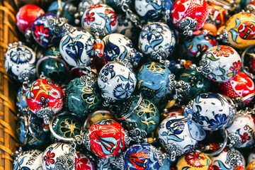 Lustrous collection of Turkish ceramic keychains in a basket, featuring traditional Iznik patterns, ideal for cultural and retail themed imagery.