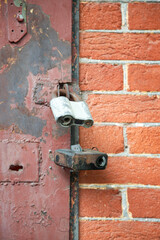 Metal red door locked with two big padlocks. Vertical shot