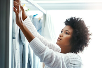 Black woman, home and hygiene with hanging laundry for housekeeping, duties and domestic. Female...