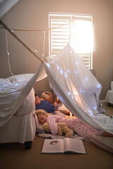 Home, bedroom and children with sleeping in tent for rest, dreaming and indoor adventure together. Boy, girl and relax with kids in blanket fort at house for fun sleepover, tired and development