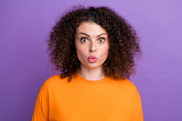 Photo of funky excited lady dressed orange t-shirt big eyes sending you kiss isolated violet color background