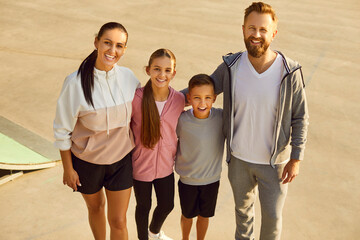 Happy sporty active family portrait, wearing sportswear standing together, enjoy good weather...