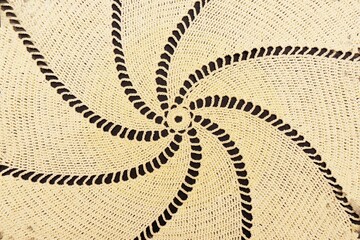 Vintage handmade white knitted napkin isolated on a black background.