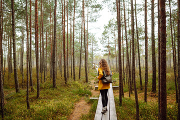 Happy female tourist walk in the autumn forest. Nature. Trips. Active lifestyle.