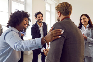 Company employees shaking hands celebrating success, making a deal, business achievement or signing...