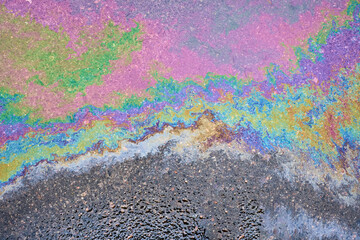 Captivating close-up of the opalescent sheen of a petrochemical spill on saturated asphalt