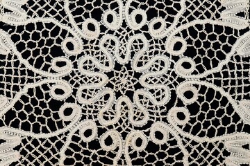 Vintage handmade white knitted napkin isolated on a black background.