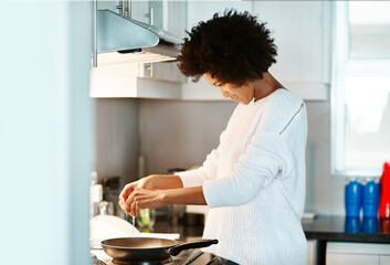 Black woman, egg and heat on stove in home, frying pan and meal preparation in kitchen. Female...