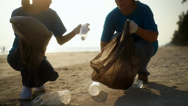 Teamwork moment of volunteer people group in volunteering charity activities cleaning up waste plastic on sand sea ocean beach . Corporate social responsibility and society activity for Environment.