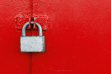 Padlock on a steel red door. Lock on the gate. Safety - Powered by Adobe