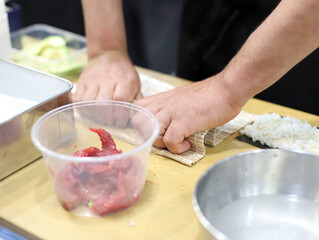 cocinero experto en sushi elaborando rollo de sushi artesanalmente