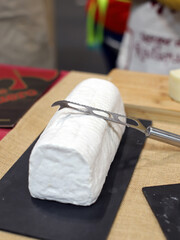 queso artesanal de cabra camembert en tabla de pizarra con cuchillo especial de partir queso