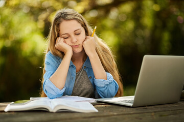 Stress, girl and student study outdoor at park for burnout, tired or sad for exam fail on university laptop. Depression, fatigue or woman at college campus frustrated at learning challenge or anxiety