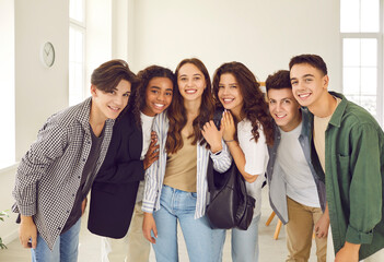 Portrait of a group of happy smiling diverse high school students and classmates in casual clothes...