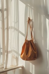 A bag hanging on a wall next to a window. Suitable for interior design concepts