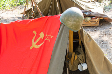 WWII Soviet military camp with tents, Soviet flag with assault helmet