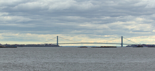 Verrazzano Narrows Bridge in the distance seen from liberty state park at sunset (cloudy dramatic...