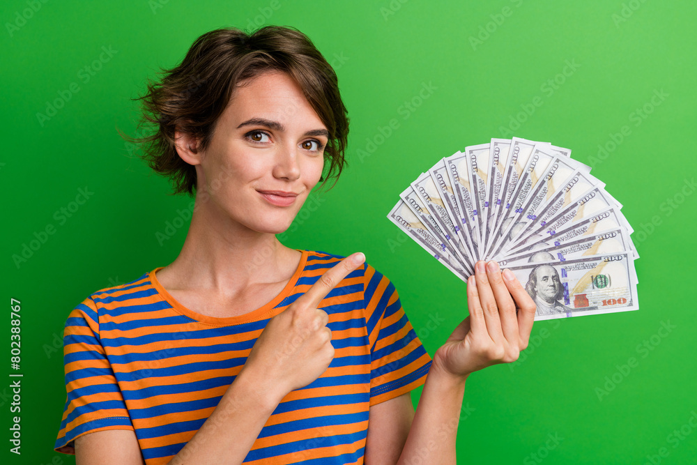 Canvas Prints Photo portrait of lovely young lady finger point money fan credit dressed stylish striped garment isolated on green color background