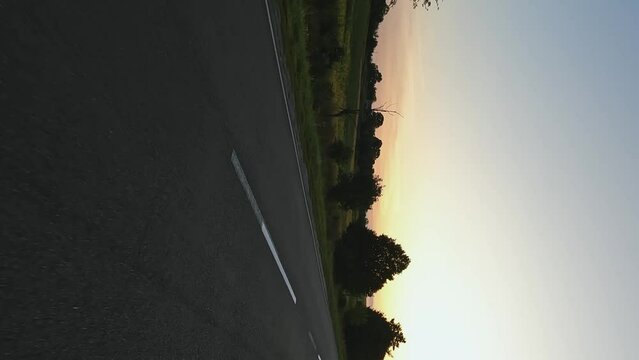 Vertical video - road and sunset. Concepts of travel, movement, driving, distance, ecology, inspiration, calm, dreams, motivation, transport, sports, speed, emotions, adrenaline, impressions, silence
