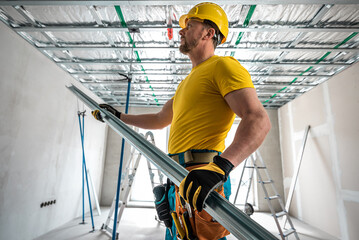 Plasterboard worker making a plasterboard ceiling. Assembling the support structure from CD...
