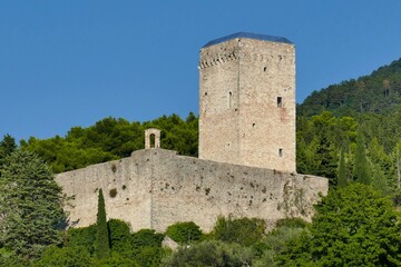 Fototapeta na wymiar Tour et rempart de La forteresse Rocca Maggiore dominant la ville d’Assise en Italie