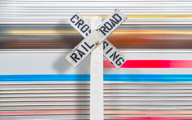 Train Speeding Past A Railroad Crossing Sign