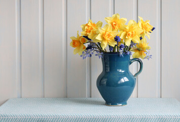 yellow garden terry daffodils in a blue jug.