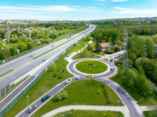 Three lane motorway A4 in Krakow, Poland. Entrance ramp and exit ramp with a traffic circle, cars...