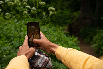 A young attractive guy takes a photo on his phone. Beautiful nature.