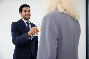 businessman with businesswoman drinking beer and clinking glasses in the office