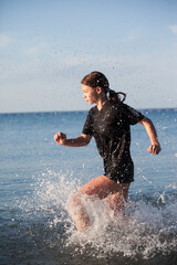 Teenage girl training and running through water