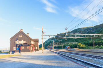 Historic Hjerkinn railway station lines, featuring traditional architecture and a serene mountain...