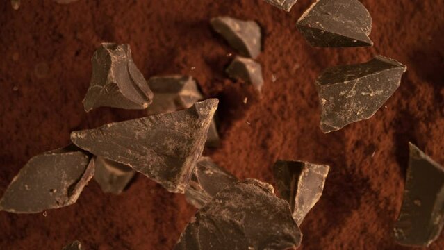 Super Slow Motion of Falling Group of chocolate pieces. Falling Down into Cocoa Powder. Filmed on High Speed Cinema Camera, 1000fps.