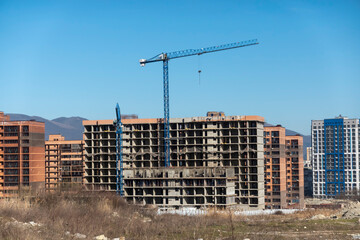 Fototapeta premium Novorossiysk Two hoisting cranes and buildings under construction