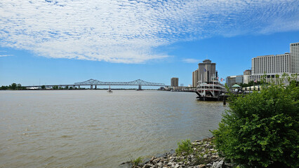 a gorgeous spring landscape along the MIssissippi River with boats sailing and the Crescent City...