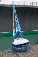 Tied rope on the knot around the mooring bollard. Nautical theme background