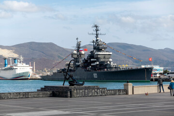 Novorossiysk, Russia - 18 August 2023. Cruiser Mikhail Kutuzov and dolphins, Black Sea, port,...