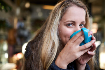 Portrait, drink or woman with coffee in cafe to relax, chill and enjoy a warm beverage in...