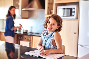 Child, homework and portrait of girl in home for education, learning or working on school assessment in kitchen. Smile, student and young kid with notebook for knowledge, development or writing