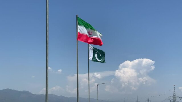 The flag of friendship between Pakistan and Iran is waving, the colorful flag of Pakistan and the national flag of Iran are waving.