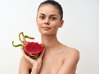 Beautiful young woman holding a dragon fruit on white background with copy space for text or design...