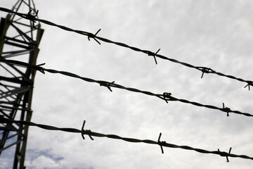 Three strands of barbed wire on the impassable border of the restricted area. in black and white tones