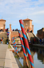 mooring poles for boats in the navigable canal and the ancient bridge of COMACCHIO in Italy