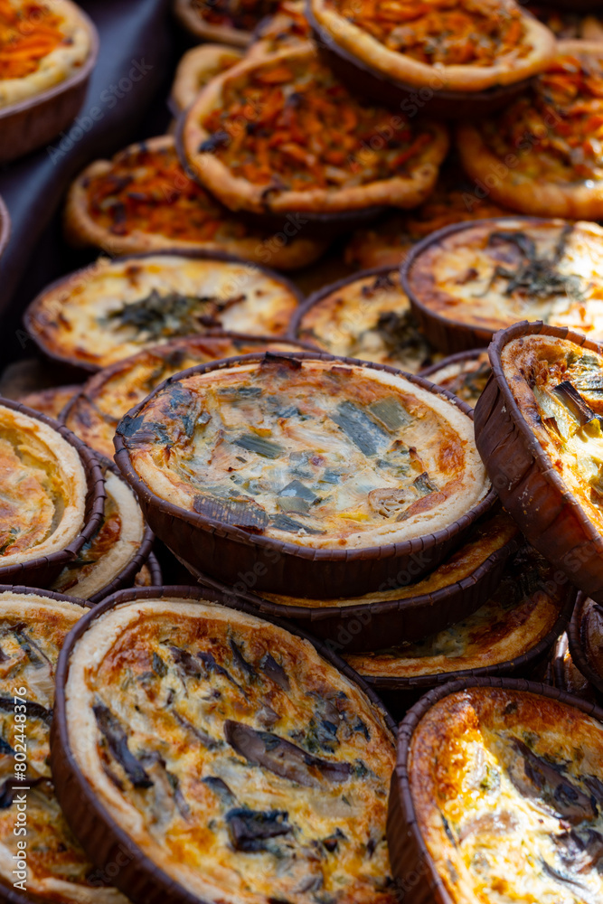 Wall mural Tasty vegetarian streetfood for lunch in London, various quiche savoury tart swith spinach, tomatoes, mushrooms, cheddar cheese